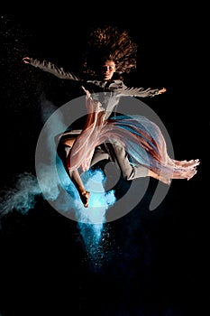 Beautiful woman elegantly jump high in the air at dark time