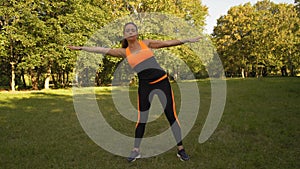 Beautiful Woman Engaged in Fitness in the Morning on the Glade in the Forest