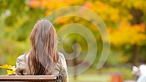 Beautiful woman enjoy warm day in autumn park under fall foliage