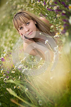 Beautiful woman enjoying daisy field, nice female lying down in meadow of flowers, pretty girl relaxing outdoor, having fun, holdi