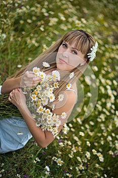 Beautiful woman enjoying daisy field, nice female lying down in meadow of flowers, pretty girl relaxing outdoor, having fun, holdi