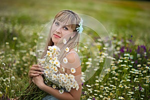 Beautiful woman enjoying daisy field, nice female lying down in meadow of flowers, pretty girl relaxing outdoor, having fun, holdi