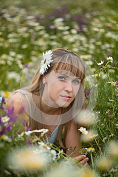 Beautiful woman enjoying daisy field, nice female lying down in meadow of flowers, pretty girl relaxing outdoor, having fun, holdi