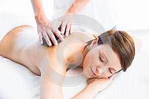 Beautiful woman enjoying hot stone massage