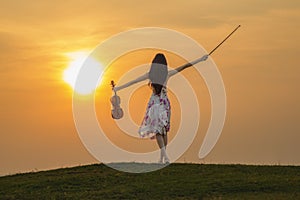 Beautiful woman enjoying music at sunset