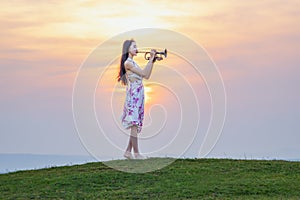 Beautiful woman enjoying music at sunset