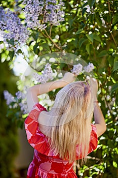 Beautiful Woman Enjoying the Smell of Lilac. Cute Model and Flowers.