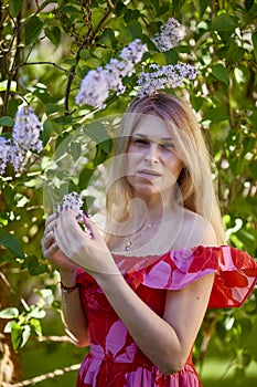 Beautiful Woman Enjoying the Smell of Lilac. Cute Model and Flowers.