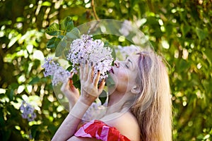 Beautiful Woman Enjoying the Smell of Lilac. Cute Model and Flowers.