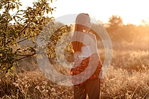 Beautiful woman enjoys freedom and beauty at sunset