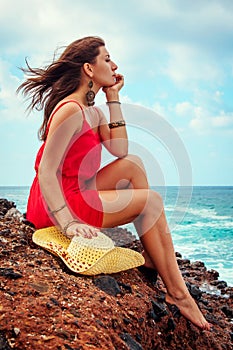 Beautiful woman enjoys the view of waves on the beach