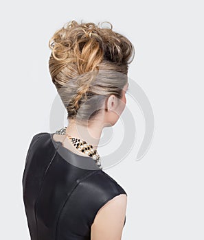 Beautiful woman with evening salon hairdo. Complicated hairstyle for party