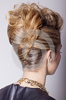 Beautiful woman with evening salon hairdo. Complicated hairstyle for party