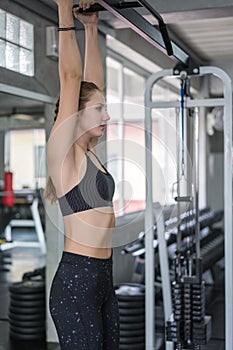 Beautiful woman exercise pull up bar in fitness gym at sport club