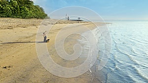 Beautiful woman exercising yoga on the Sanur beach