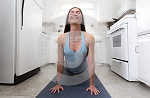 Beautiful woman exercising yoga in tiny house kitchen, multitasking, fitness, motivational inspiration