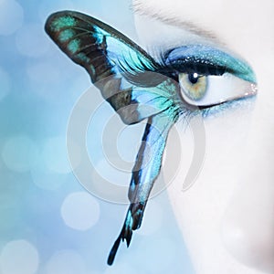 Beautiful woman eye close up with butterfly wings