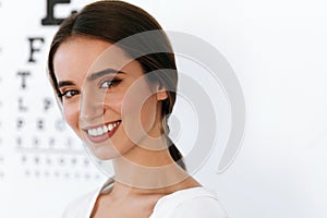 Beautiful Woman With Eye Test Chart At Ophthalmology Office