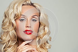 Beautiful woman face with blonde hair, red lips make up and black eyeliner arrow on eyes