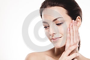 Beautiful woman face close up portrait touching her cheek by palm isolated on white