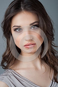 Beautiful woman face close up portrait young studio on gray. Natural beauty