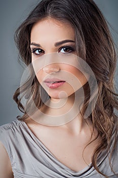 Beautiful woman face close up portrait young studio on gray. Natural beauty