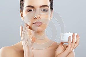 Beautiful Woman With Face Cream. Skin Protection. Skin Care. Spa. A Young Female Holds Moisturizing Cream.