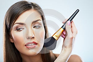 Beautiful woman face. Make up applying with brush.