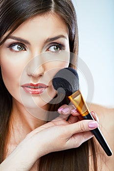 Beautiful woman face. Make up applying with brush.