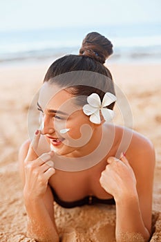 Beautiful Woman Face Portrait Beauty Skin Care Concept. Suncream. Suntan Lotion Beautiful Woman Applying on beautifu on Face.