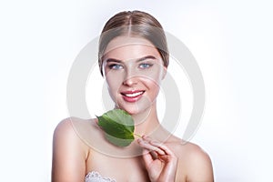 Beautiful woman face portrait with green leaf concept for skin care or organic cosmetics. Studio portrait