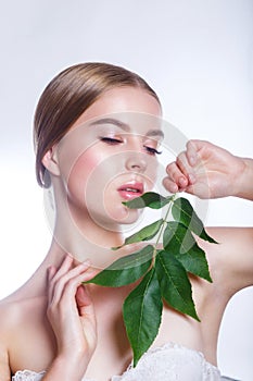 Beautiful woman face portrait with green leaf concept for skin care or organic cosmetics. Studio portrait