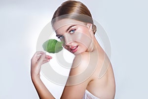 Beautiful woman face portrait with green leaf concept for skin care or organic cosmetics. Studio portrait