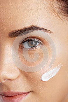 Beautiful woman face. Skincare habits. Face of young woman. Girl taking care of her dry complexion applying moisturizing cream.