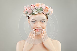 Beautiful woman face. Spa model girl with clear skin, hand with manicured nails and roses flowers on head