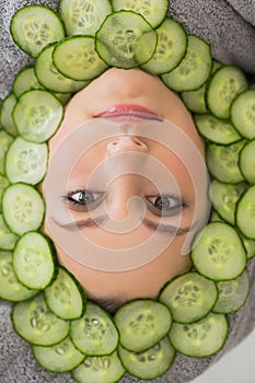 Beautiful woman with facial mask of cucumber slices on face