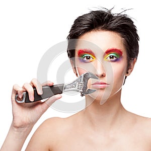 Beautiful woman with fantasy makeup holding wrench