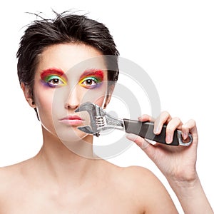 Beautiful woman with fantasy makeup holding wrench