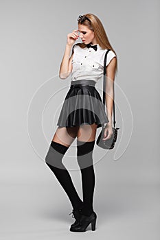 Beautiful woman is in fashion style in black mini skirt. Fashion girl