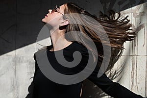 Beautiful woman in fashionable summer spring clothes outdoors. Hair movement of sensual brunette woman. Female stylish