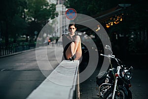 Beautiful woman in fashionable summer spring clothes outdoors near bike. Female stylish model walking city street