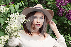 Beautiful woman in fedora hat outdoors. Country style fashion portrait