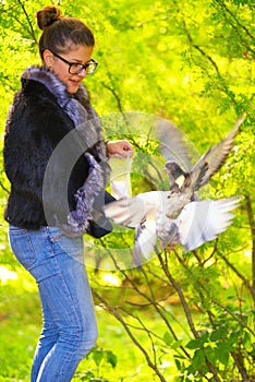 Beautiful woman feeding pigeons in the park