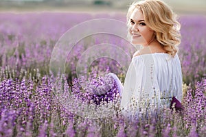 Beautiful woman in a field of blossoming lavender