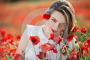 Beautiful woman in field of poppy flowers