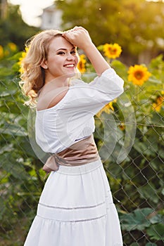 Beautiful woman in a field of sunflowers blooming