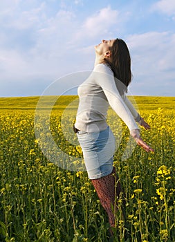 Beautiful woman in field with yellow flowers.