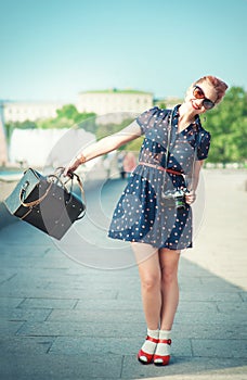 Beautiful woman in fifties style with braces holding retro camera