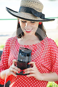 Beautiful woman in fifties style with old camera