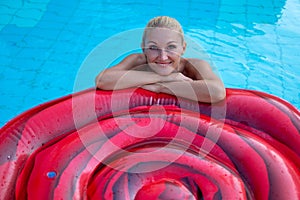 Beautiful woman floating on an inflatable mattress in a reservoir of the beautiful hotels